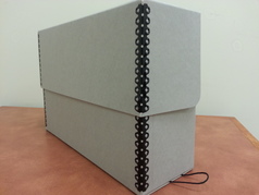 Many archives use a gray Hollinger box (as displayed in this picture) to store materials safely.